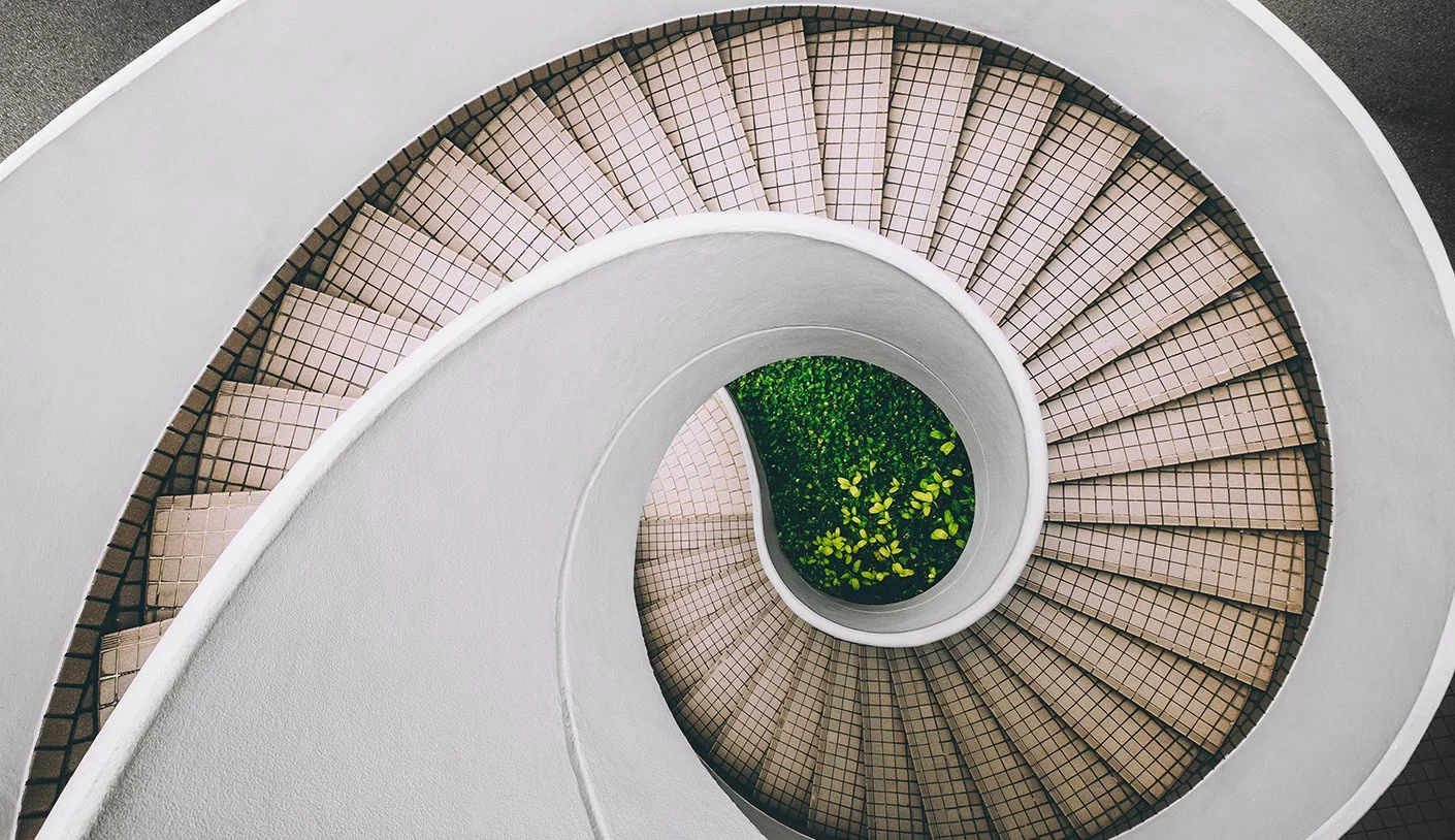 Tiled spiral stairs descending to garden